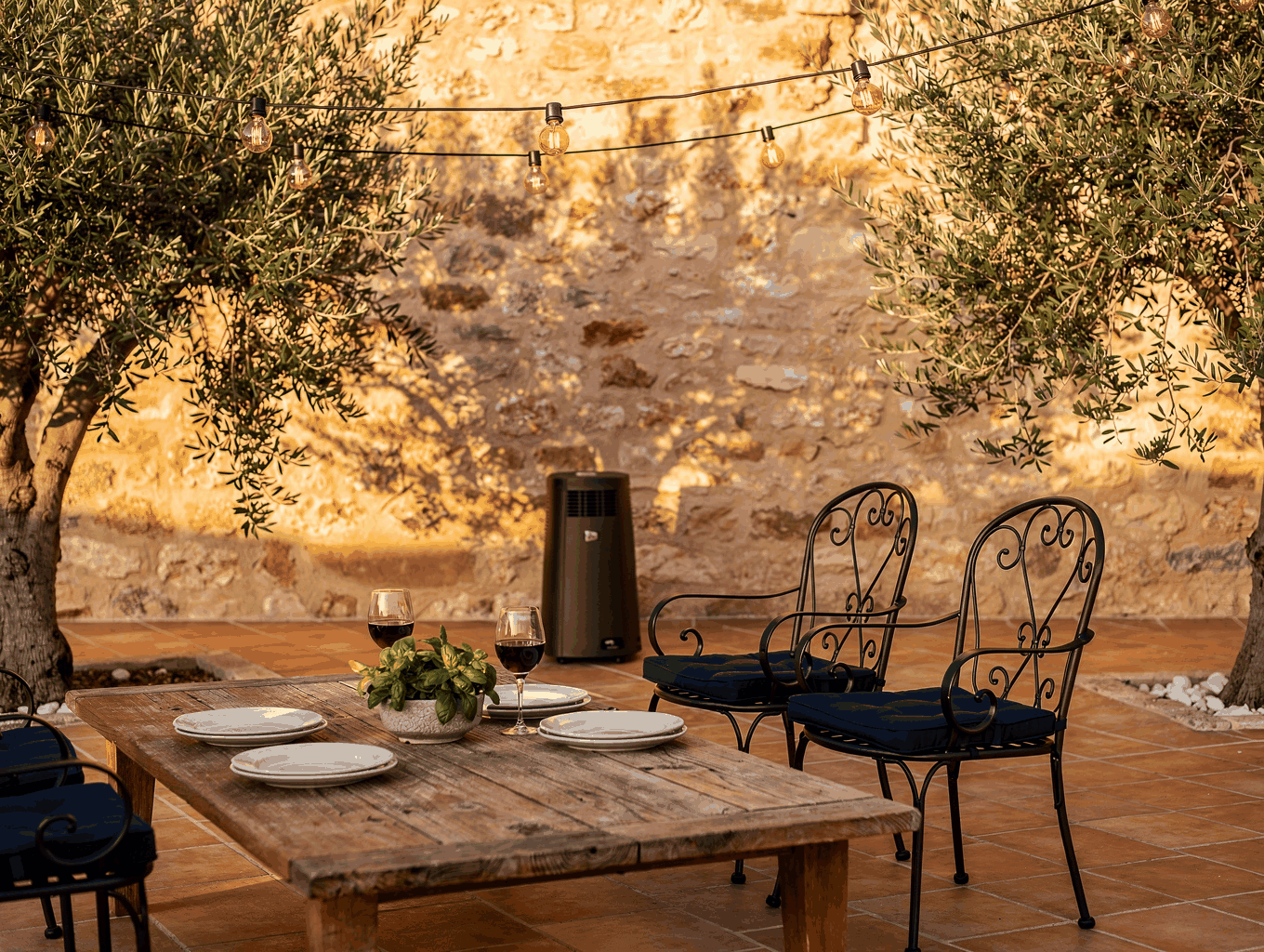 Heated covered outdoor terrace decorated with olive trees and festoon lighting